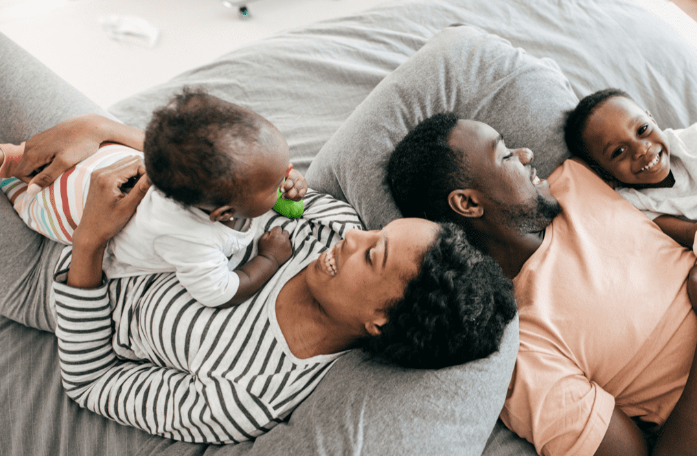Parents and children laying down smiling