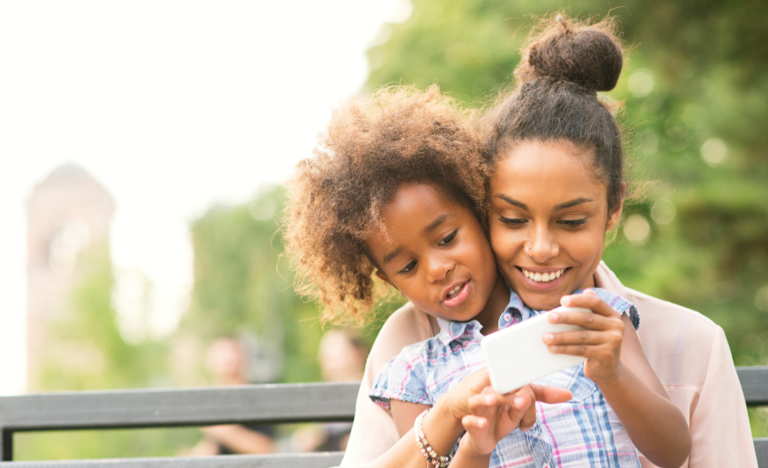 Mother and daughter using smartphone in the park