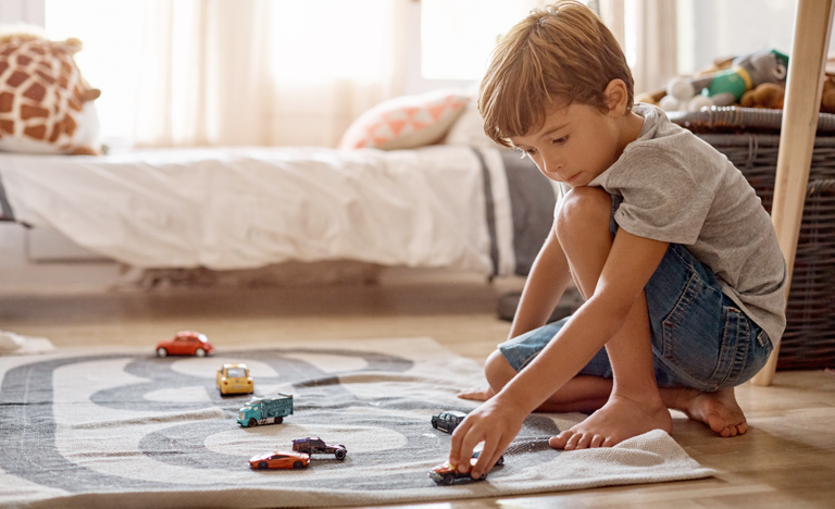 Little boy playing with his toys at home