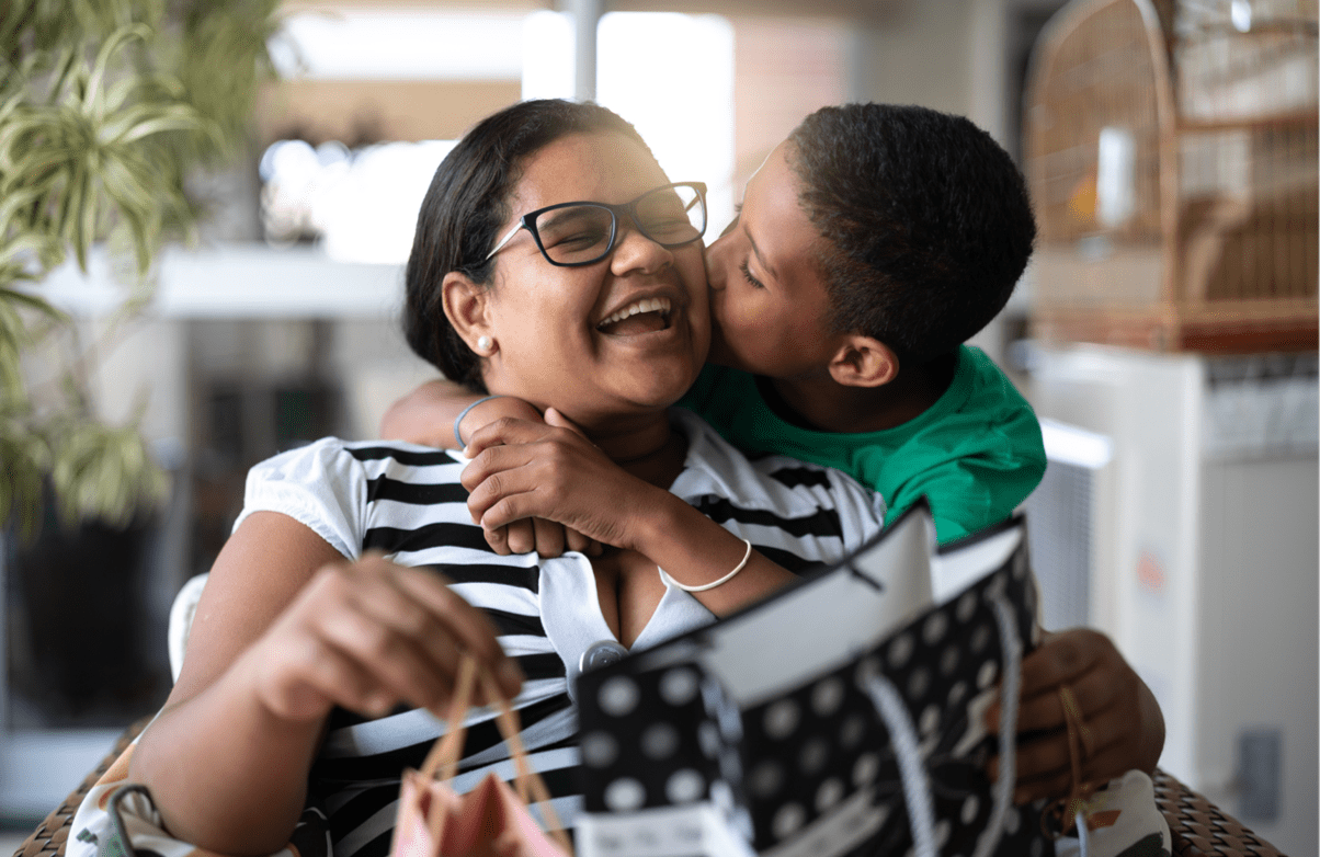 Mother and son embracing and receiving gifts
