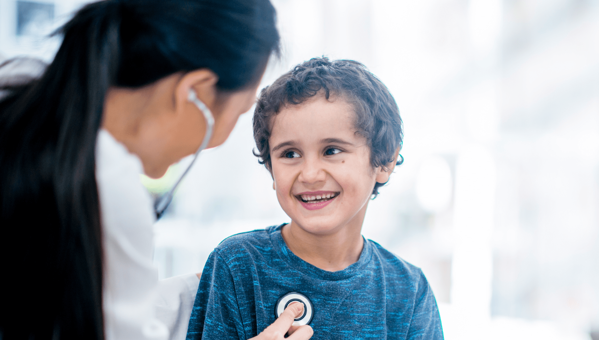 Female doctor checking young boy&rsquo;s heart rate