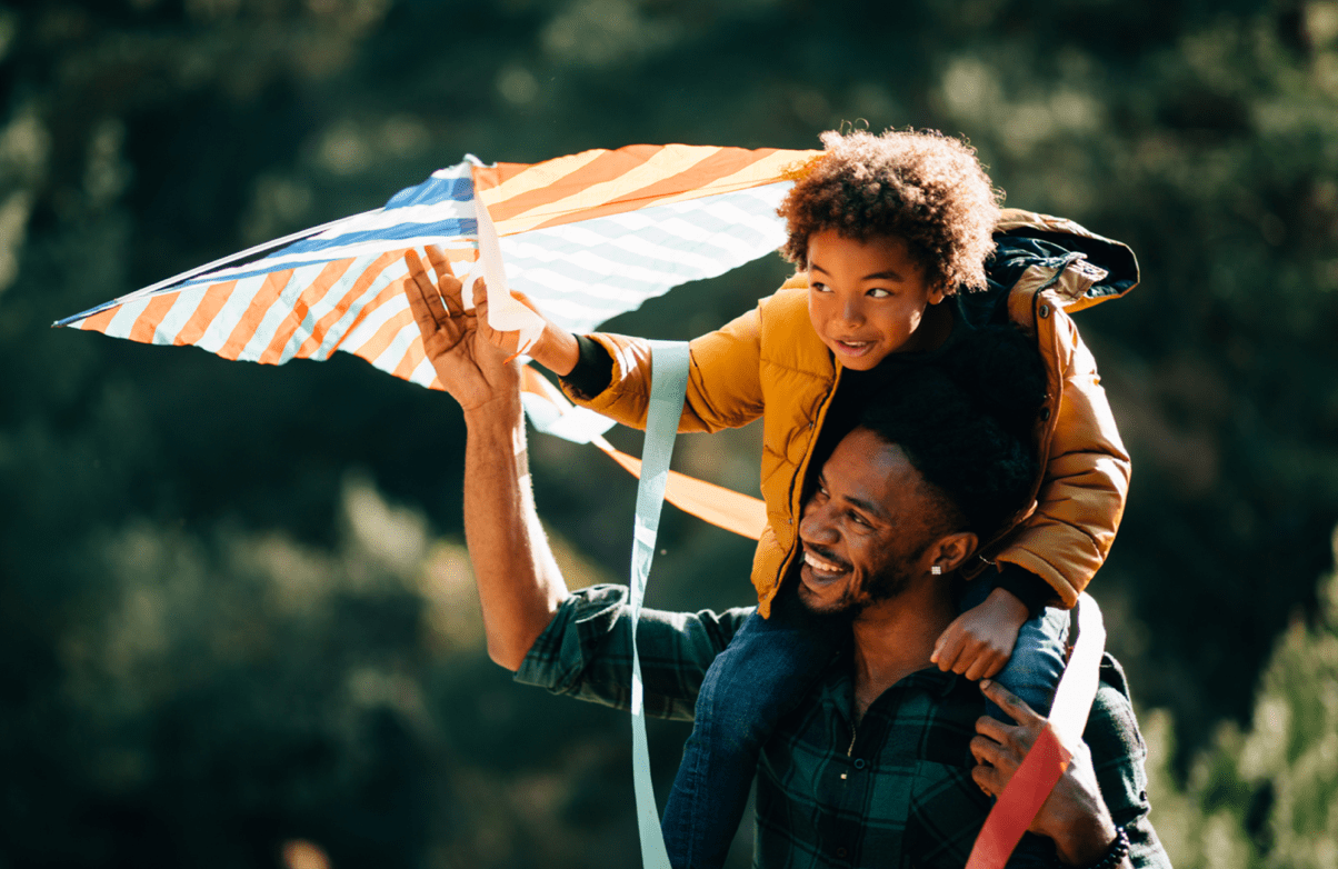 Father and son having fun flying a kite