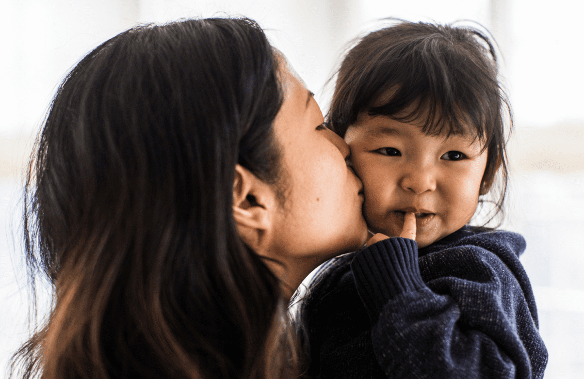Mother kissing daughter on cheek
