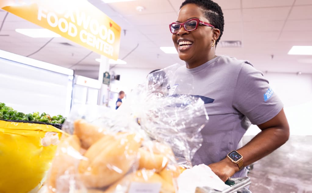 A BlueCross BlueShield of Tennessee Team Blue volunteer transporting groceries at a food center