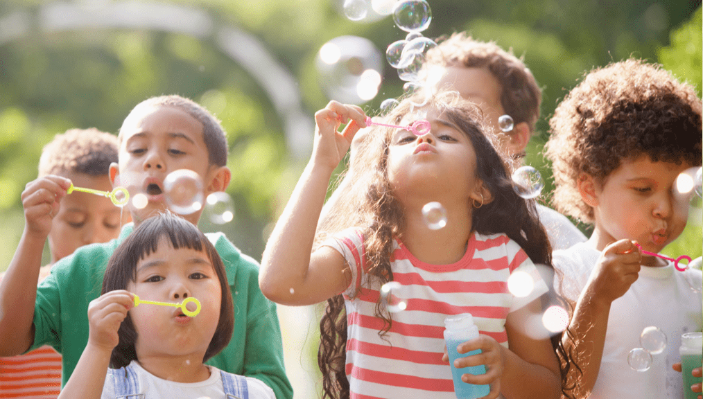 Children outdoors blowing bubbles
