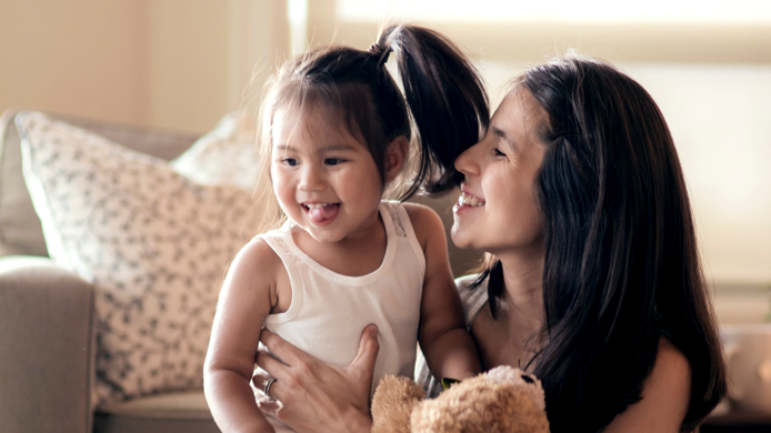Young mother smiling at her young daughter