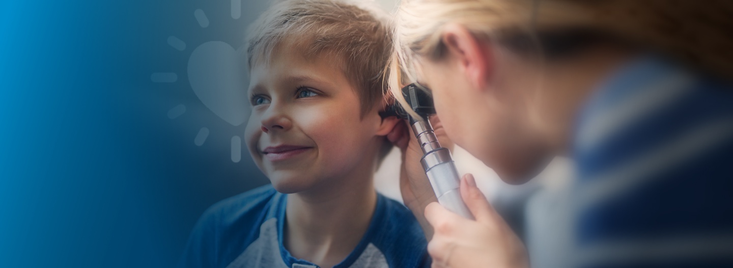 Young boy getting ears checked with otoscope