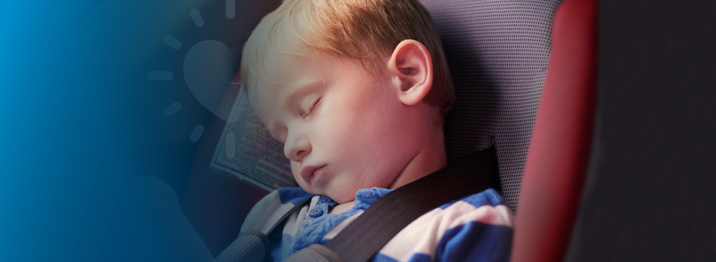 Young boy asleep in car seat