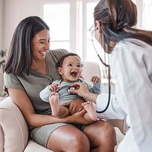 Doctor using a stethoscope to check a young patient's heart.